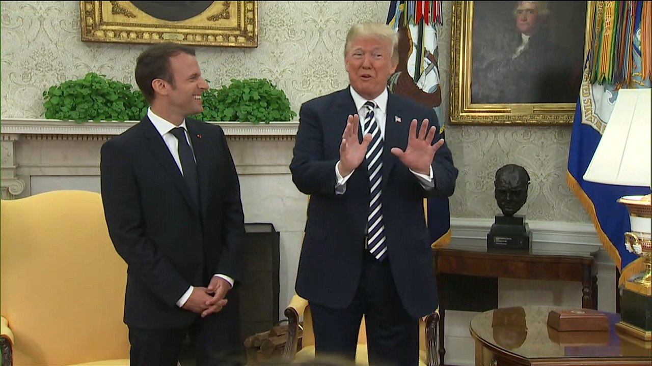 Trump balaye les pellicules sur le costume de Macron