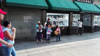FAMILIA CANTANDO ALABANZAS EN LAS CALLES DEL ZÓCALO DE  LA CIUDAD DE MÉXICO.