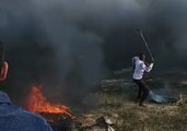 Crowds Stand Behind Large Plumes of Smoke Rising From Burning Tires