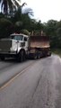 Un camion qui transporte un bulldozer part en glissade dans la pente tellement le chargement est lourd