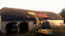 Cet agriculteur tente d'agrandir l'entrée de sa ferme avec un engin.