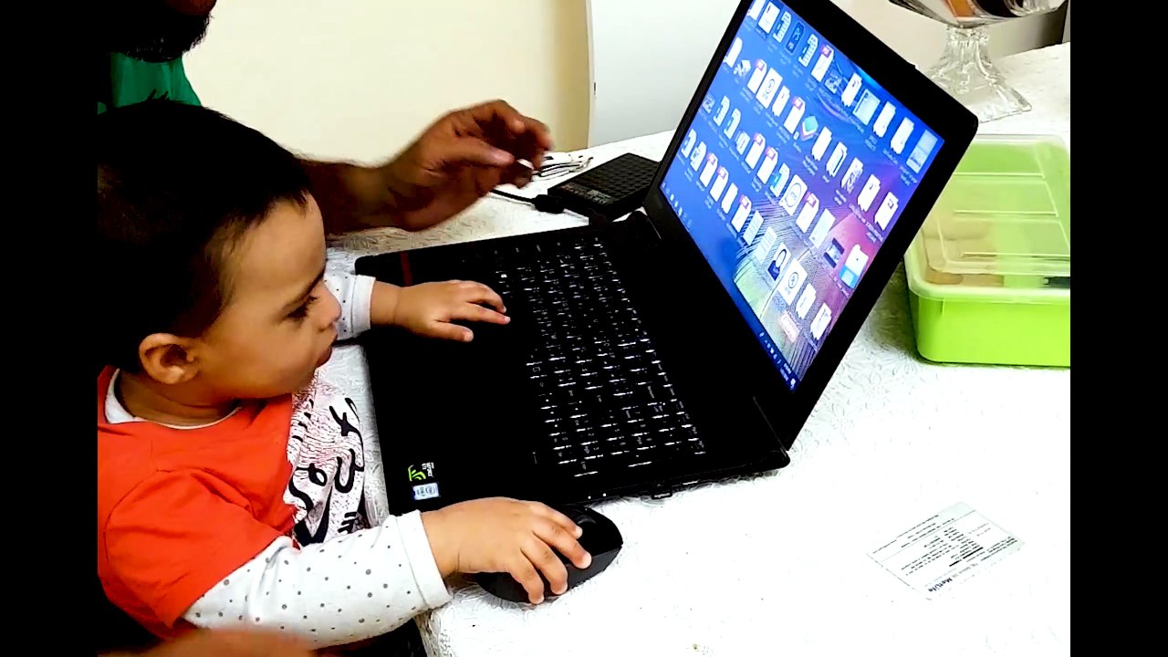 toddler playing with laptop