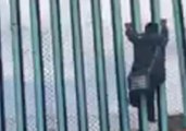 Demonstrators, Migrants Climb US-Mexico Border Fence as Caravan Arrives