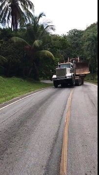 Un camion avec un bulldozer glisse sur une colline