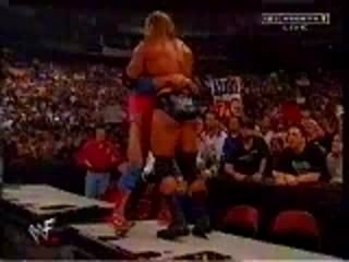 WWE - Kurt Angle belly to belly suplexes HHH off one table o