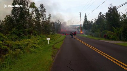 Volcanic lava crosses road in Hawaii and burns electricity pole