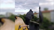 Un jeune saute dans une rivière depuis le toit d’un train en marche
