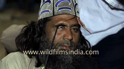 Sufi man inserts metal rod into his eye, in faith and devotion