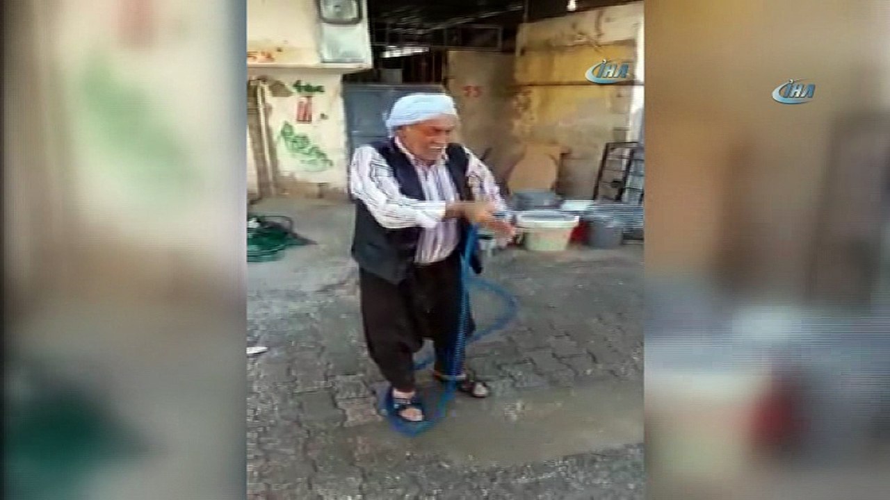 Sıcaktan bunalan yaşlı adam kendini hortumla serinletti
