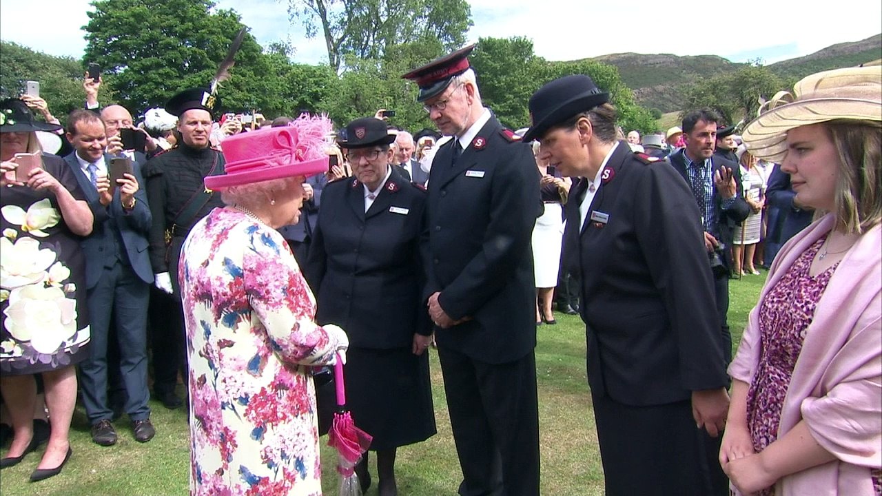The Queen laughs with guests at Holyrood garden party