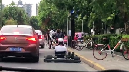Chinese go-karter weaves in and out of traffic on busy road