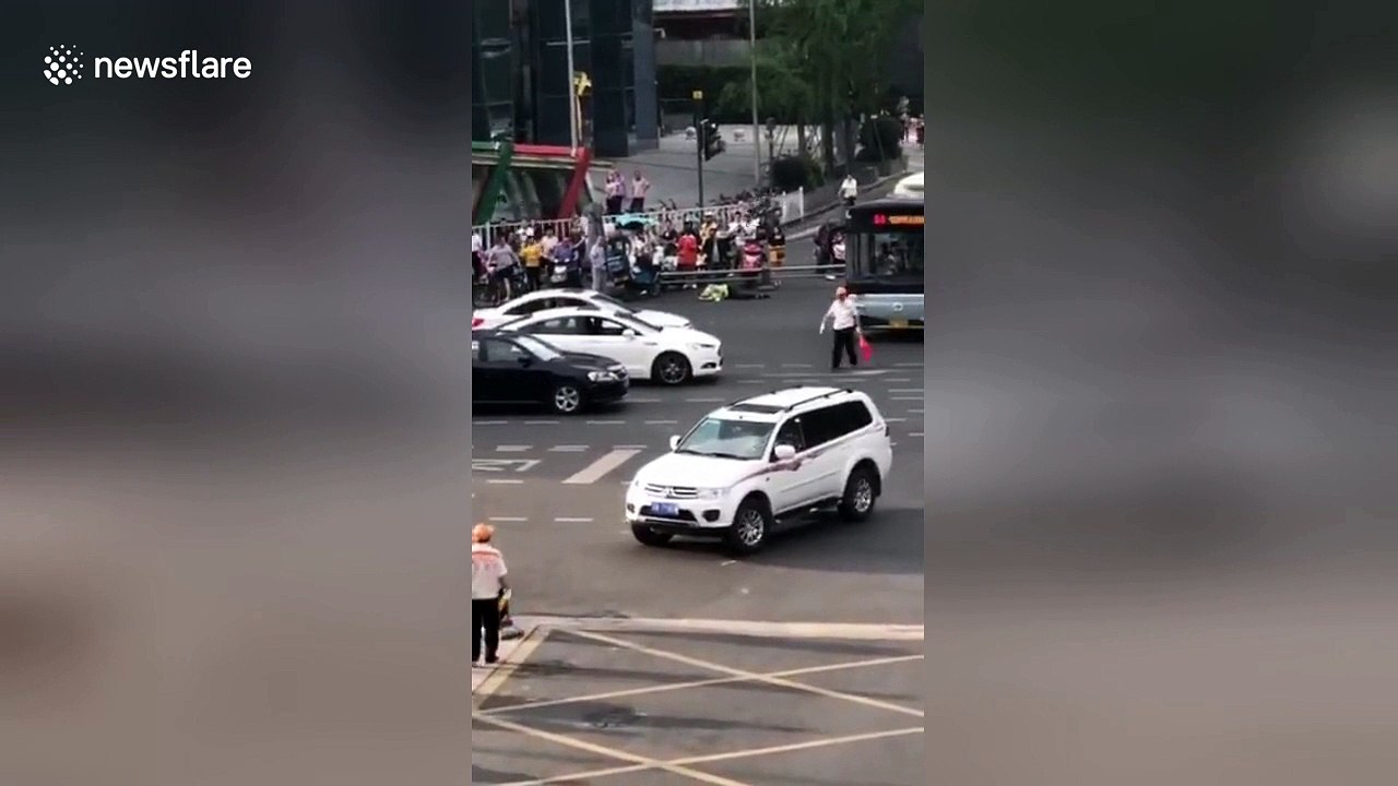 Erratic SUV driver crashes into scooter riders waiting at traffic lights