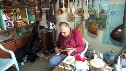 Üç telli bağlamayı hem yapıyor hem çalıyor