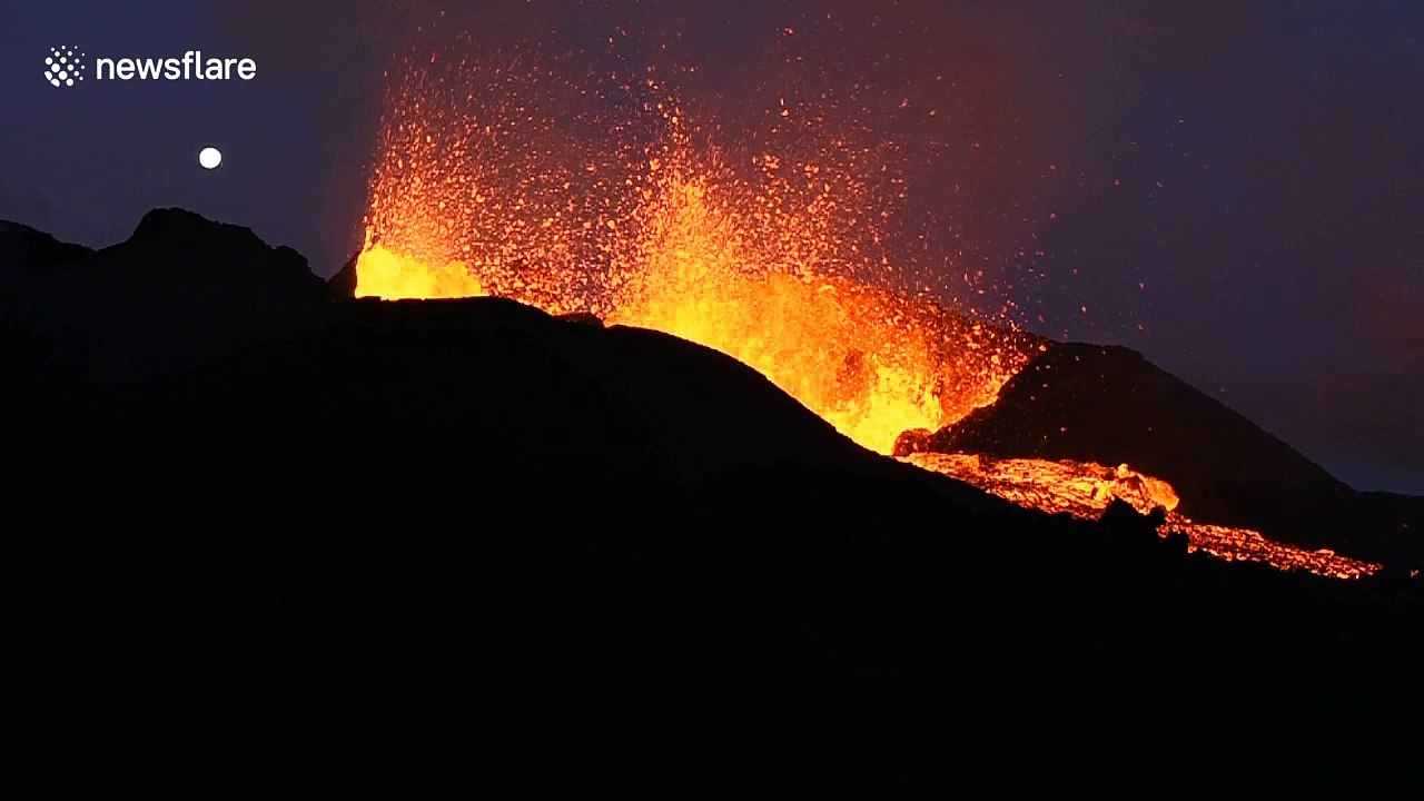 Moon rises above Reunion volcano during eruption