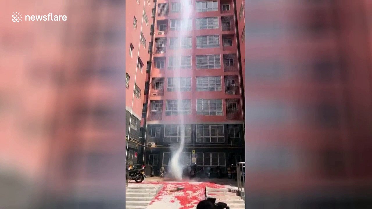 Dust devil whirls in front of residential build...