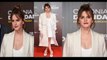 Emma Watson cuts a classy figure in a plunging white mini-dress and a stylish cream overcoat for Colonia première