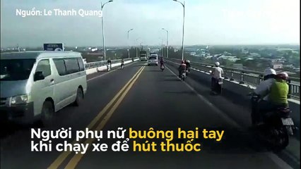 Người phụ nữ điều khiển xe máy thả hai tay, châm thuốc hút