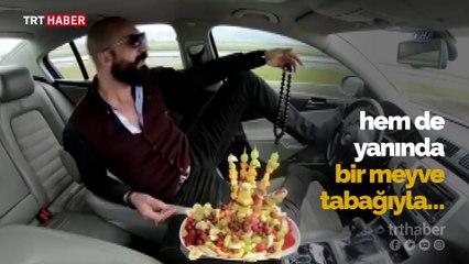 Ayağıyla direksiyonu kontrol edip meyve tabağıyla keyif yaptı