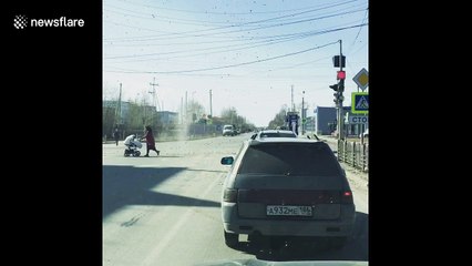 Dust devil chases old lady across street in Russia
