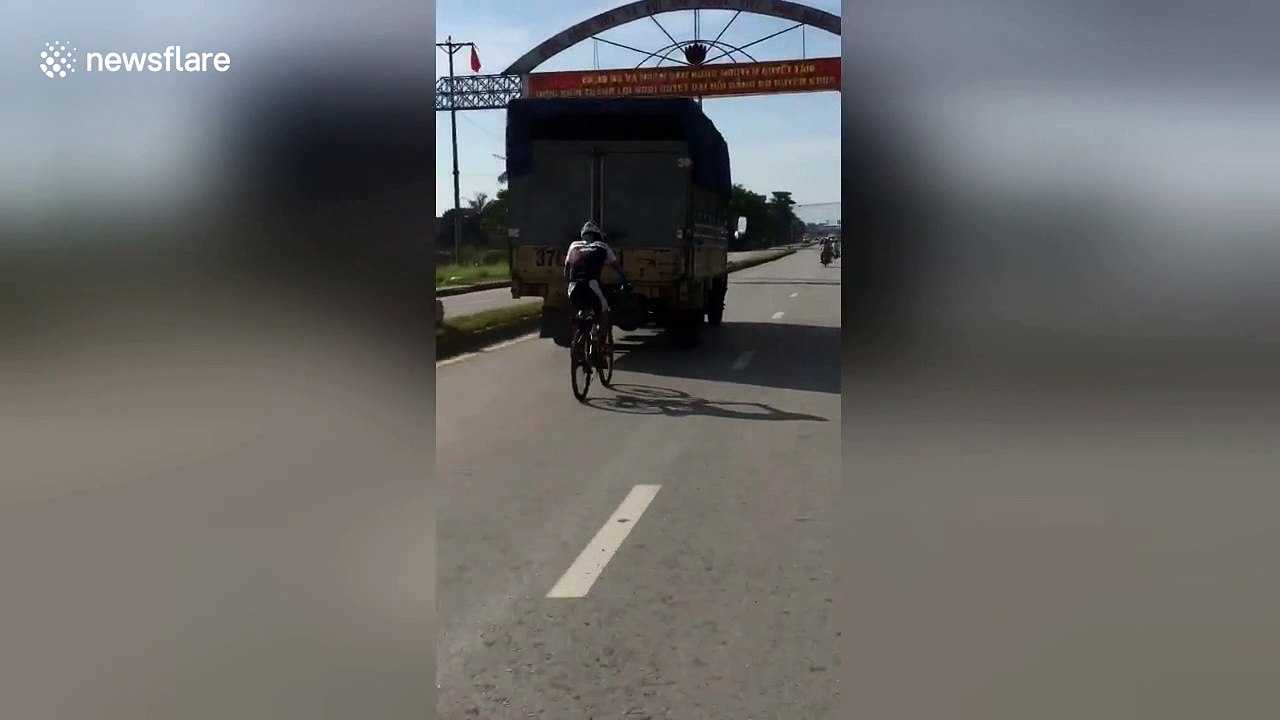 Cyclist desperate to avoid headwind positioned dangerously close to truck