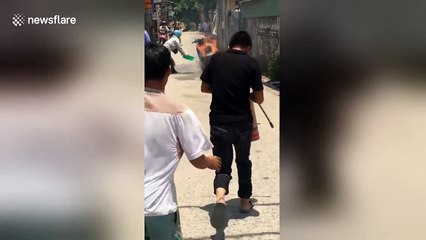 Villagers desperately try and fail to extinguish moped fire