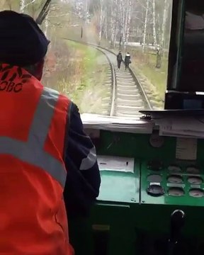 Un train fait peur à des filles sur une voie ferrée