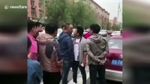 Man suddenly kisses opponent during face-off in middle of street