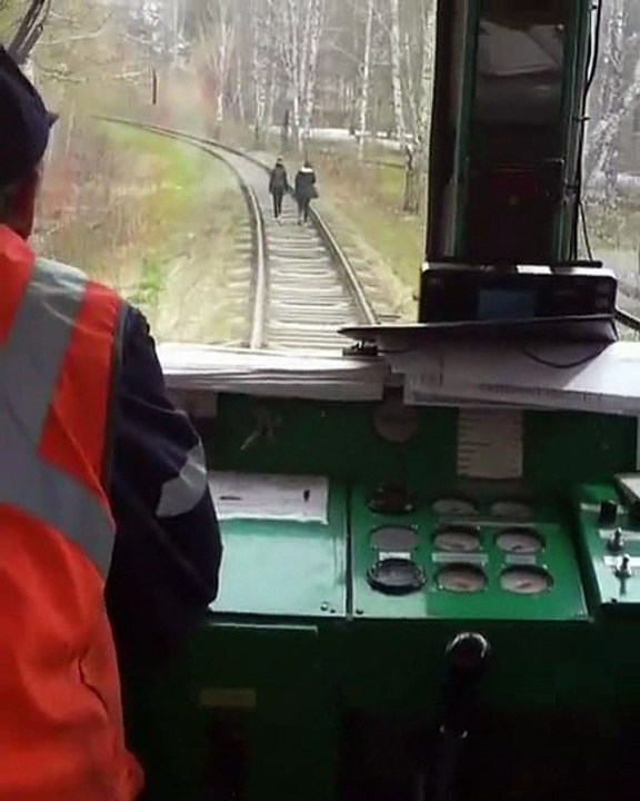Un chauffeur de train fait peur à des filles qui marchent sur la voie ferrée