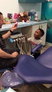 Un dentiste fait de la magie à un enfant