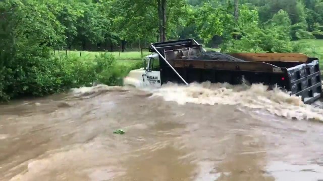 Ce camion traverse une rivière en crue tranquillement..