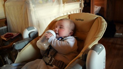 Little baby 4 months old, wants to keep a bottle of milk