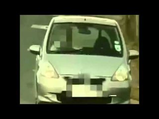 Man captured on CCTV reading a map at the wheel of his car.