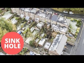 Homes evacuated after large sinkhole opened up behind row of house