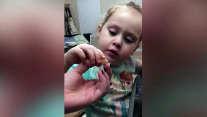Toddler girl reacts to eating sour warhead candy for the First time