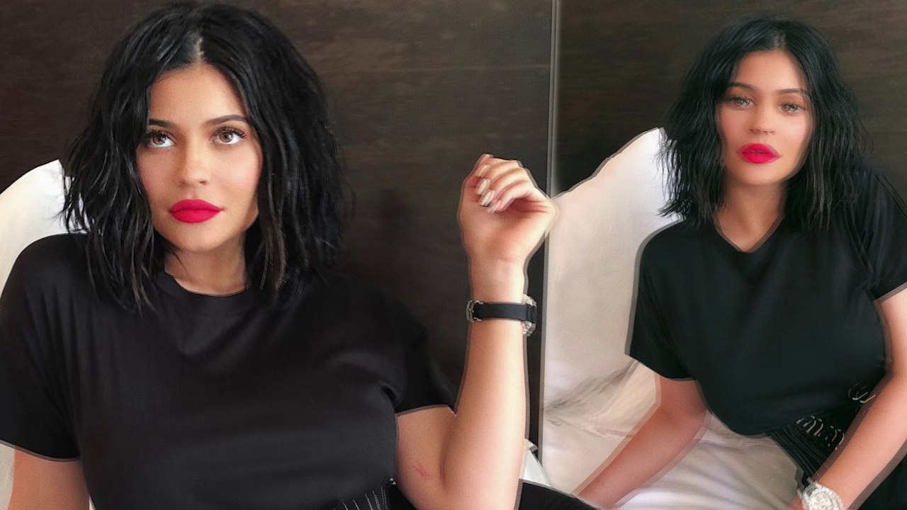 Kylie Jenner shows off sultry new lip kit as she coquettishly poses across her bed in black dress