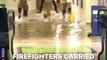 Watch firefighters carry people on piggyback out of a flooded train station