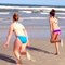 un drôle d'individu veut imiter deux filles qui font la roue sur la plage