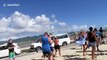 Aircraft flies over tourists' heads at Caribbean beach before airport landing