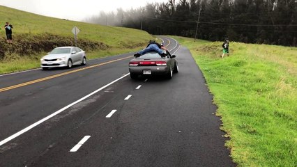 Accroché sur le toit d'une voiture pendant des donuts