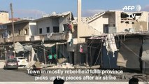 Syrians clear up the aftermath following air strikes on Binnish