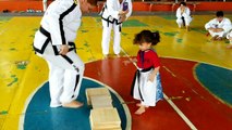 Une petite fille trop drôle qui doit casser cette planche de bois avec son pied au Taekwondo