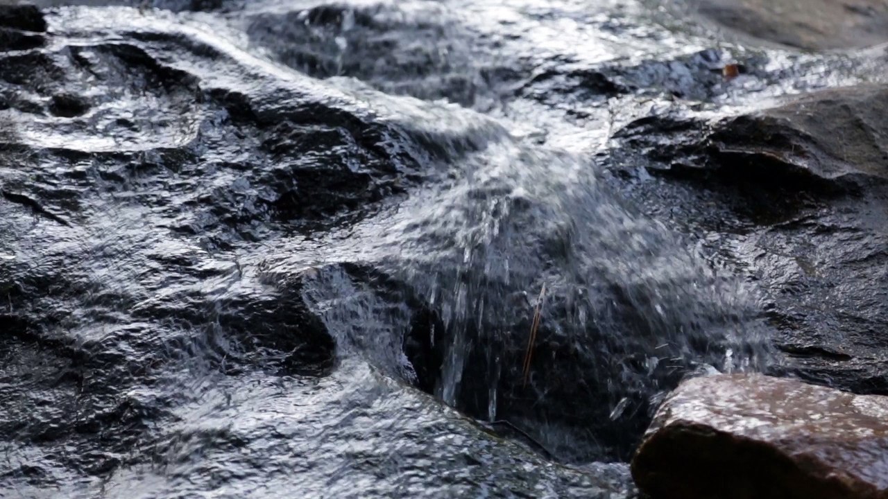 Still video shot of a rocky waterfall, loopable, royalty free.