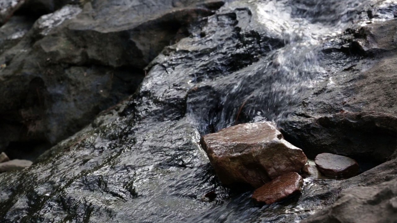 Still video shot of a rocky waterfall, loopable, royalty free.