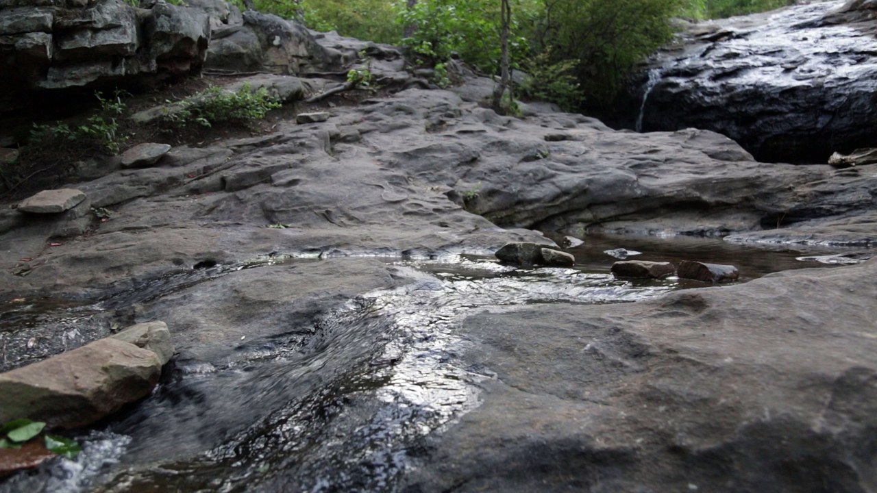 Wide shot of a rocky waterfall, loopable, royalty free.