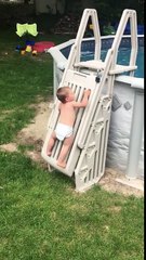 Un bébé escalade une échelle sécurisée d'une piscine
