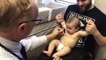 Un pédiatre distrait un bébé pendant des piqûres