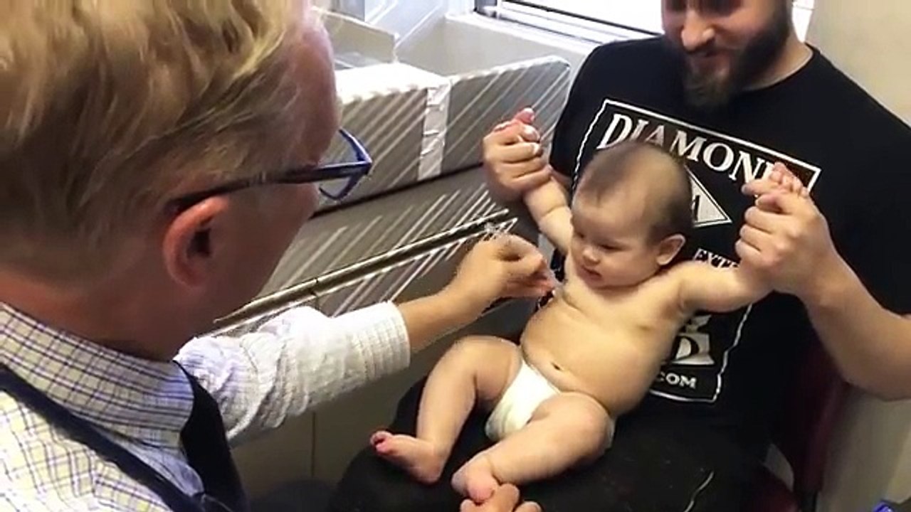 Un pédiatre distrait un bébé pendant des piqûres