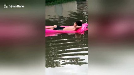 Boy lounges on pool float in the middle of severe Texas flood