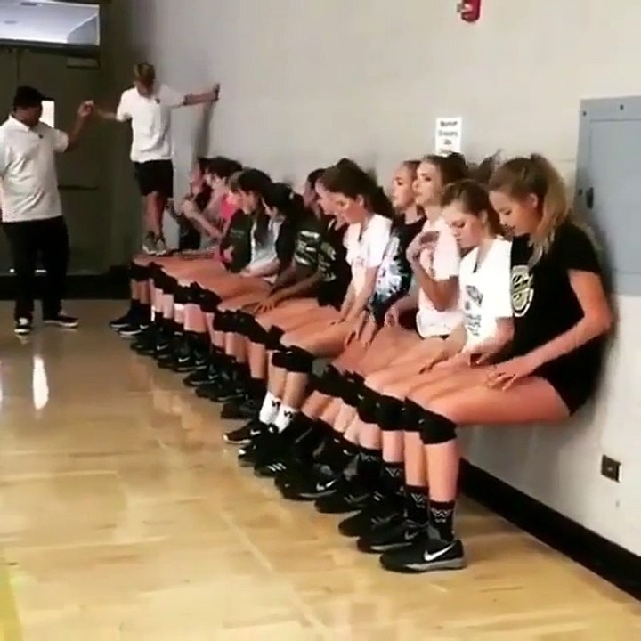 A boy walking on the legs of beautiful girls sitting around