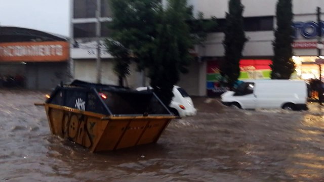 Dumpster Floats Down Flooded Street